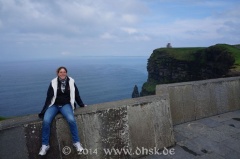 Glücklich auf der Mauer an den Klippen